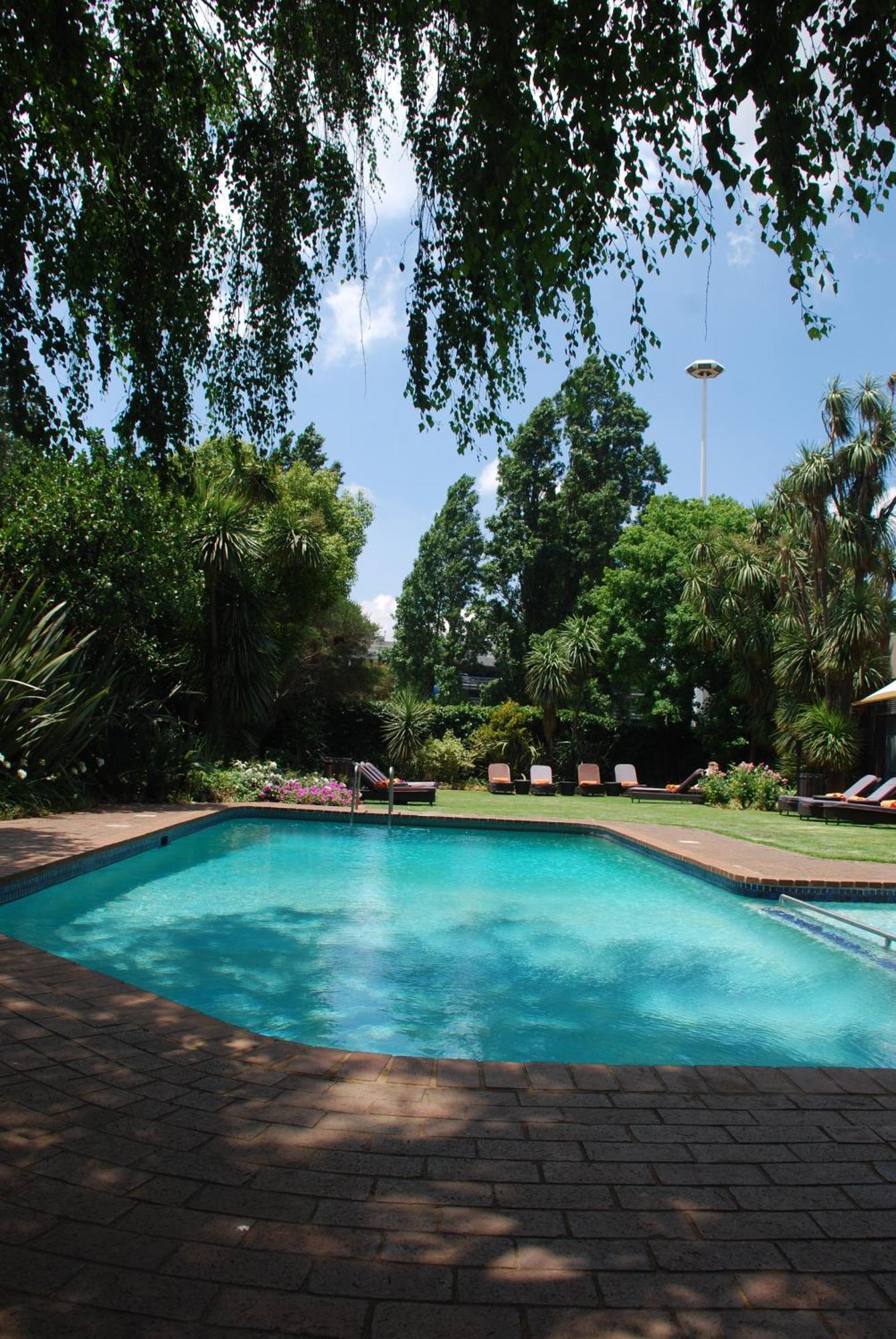 Southern Sun Or Tambo International Airport Kempton Park Eksteriør bilde The garden and swimming pool at the residence